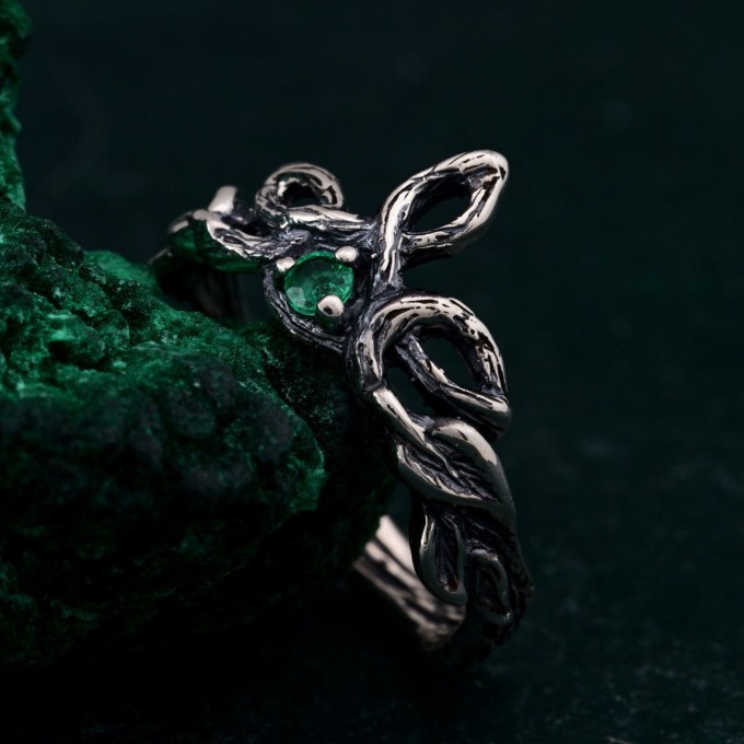 Discover the Emerald Celtic Style Wedding Band featuring a wood bark branch weave. This rustic and unique ring is perfect for those seeking a nature-inspired and distinctive wedding band.