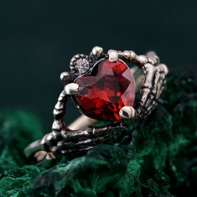 Embrace of Shadows: Gothic Skeleton Hand Garnet Ring