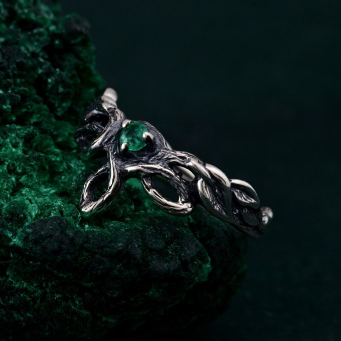 Discover the Emerald Celtic Style Wedding Band featuring a wood bark branch weave. This rustic and unique ring is perfect for those seeking a nature-inspired and distinctive wedding band.