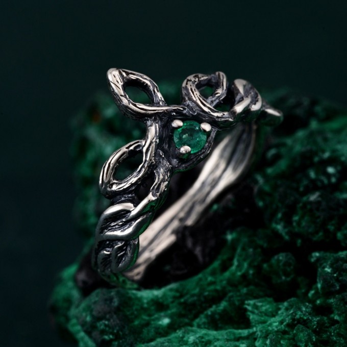 Discover the Emerald Celtic Style Wedding Band featuring a wood bark branch weave. This rustic and unique ring is perfect for those seeking a nature-inspired and distinctive wedding band.