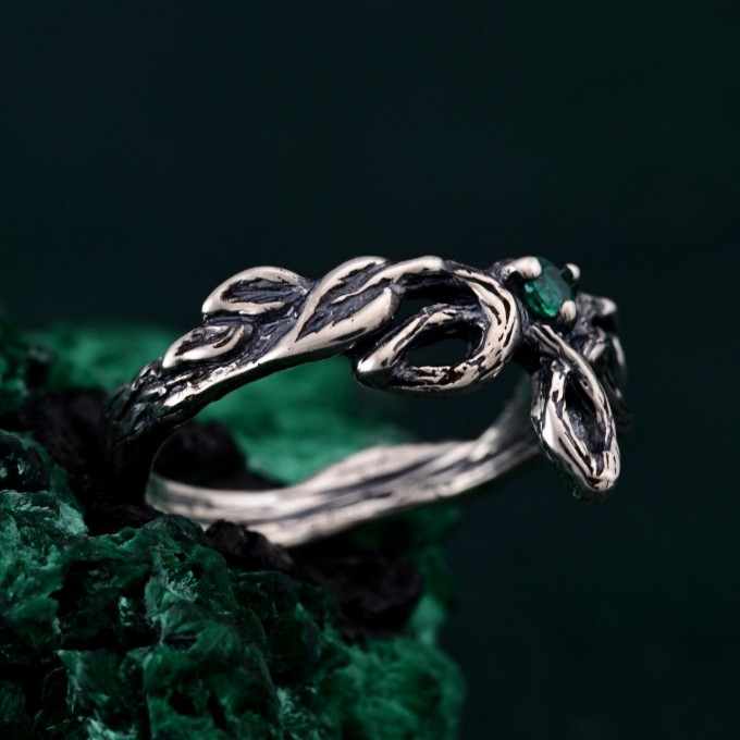 Discover the Emerald Celtic Style Wedding Band featuring a wood bark branch weave. This rustic and unique ring is perfect for those seeking a nature-inspired and distinctive wedding band.