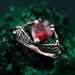 Embrace of Shadows: Gothic Skeleton Hand Garnet Ring